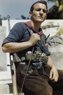 Man with rifle over his shoulder and ammunition in a belt