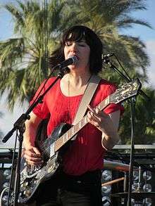 Closeup image of Brownstein singing into a microphone