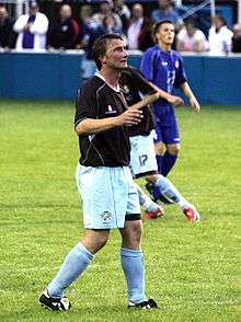 Chris Brass standing on a grass field