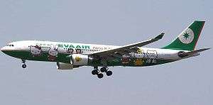 Side view of aircraft in flight; fuselage painted with cartoon faces and reads 'Hello Kitty'.