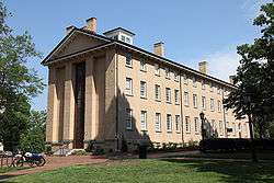 beige, brick building with many windows on the right side of the building.