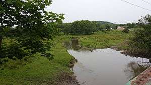 Papakating Creek in Wantage Township, New Jersey, US, a small stream flowing through green farm pastureland
