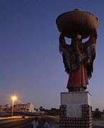 Statue towering over two men
