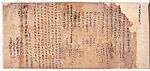 Japanese or Chinese text and red stamp marks on brown damaged paper.